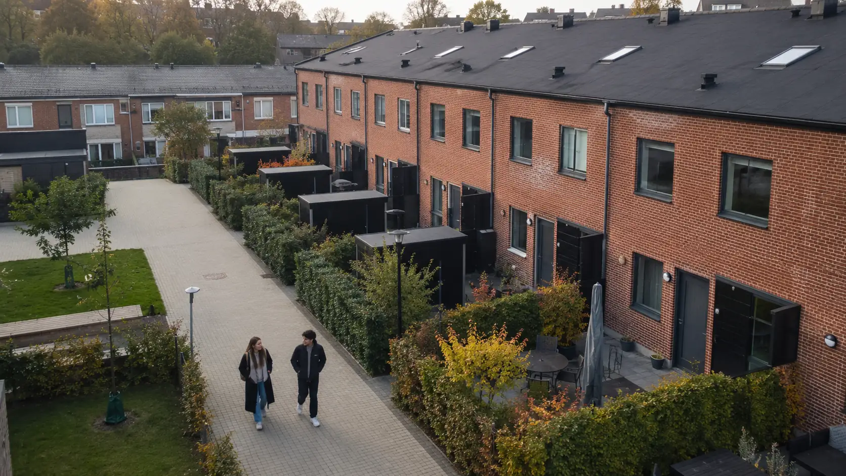 To yngre mennesker går ved nogle rækkehuse